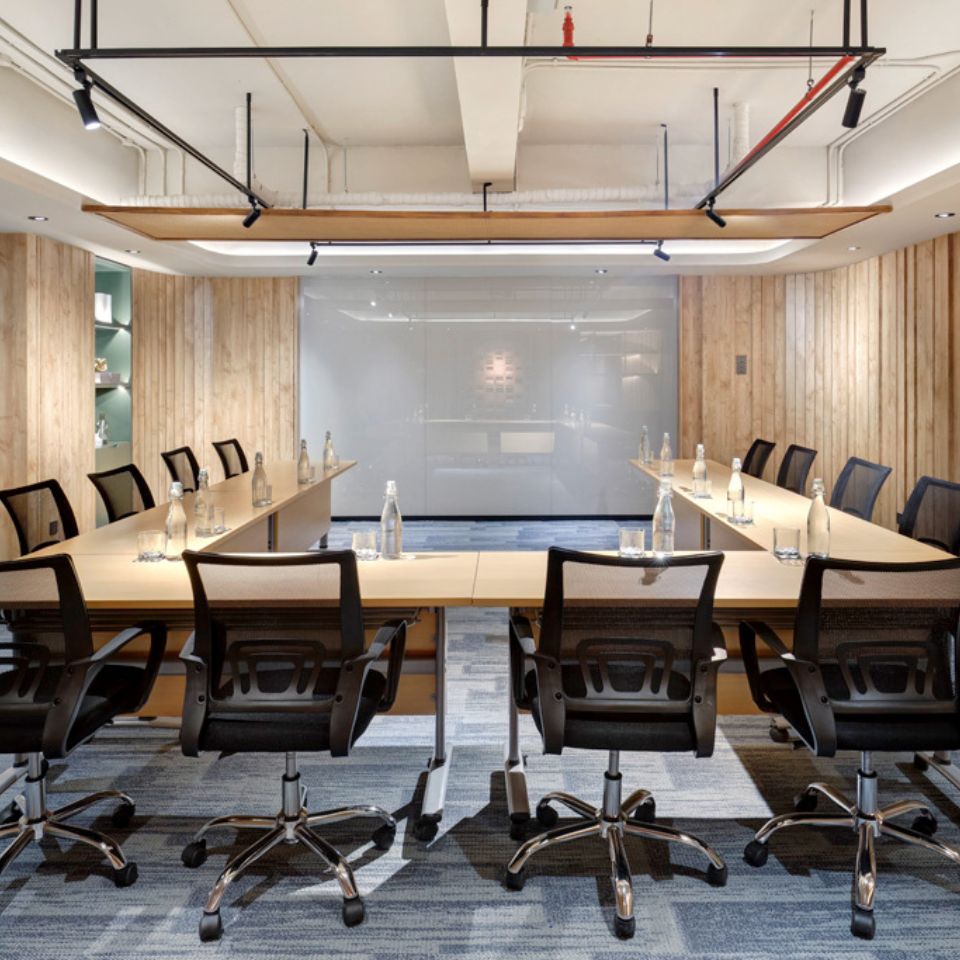 a meeting room set up in u-shaped style with 12 chairs